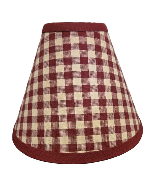 Red and white checkered lampshade on a wooden surface with a rustic background