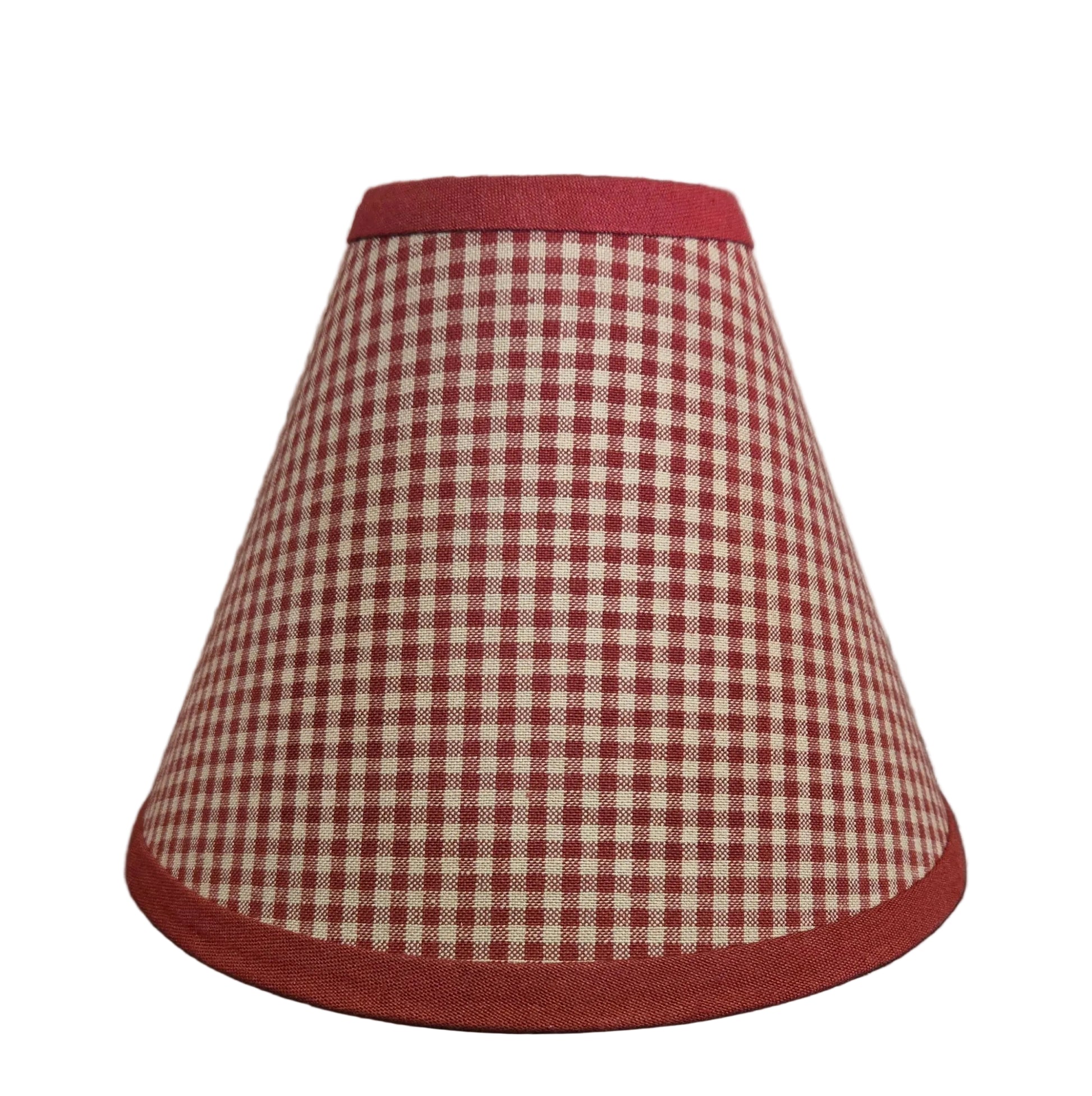 Red and white checkered lampshade on a wooden surface with a rustic background
