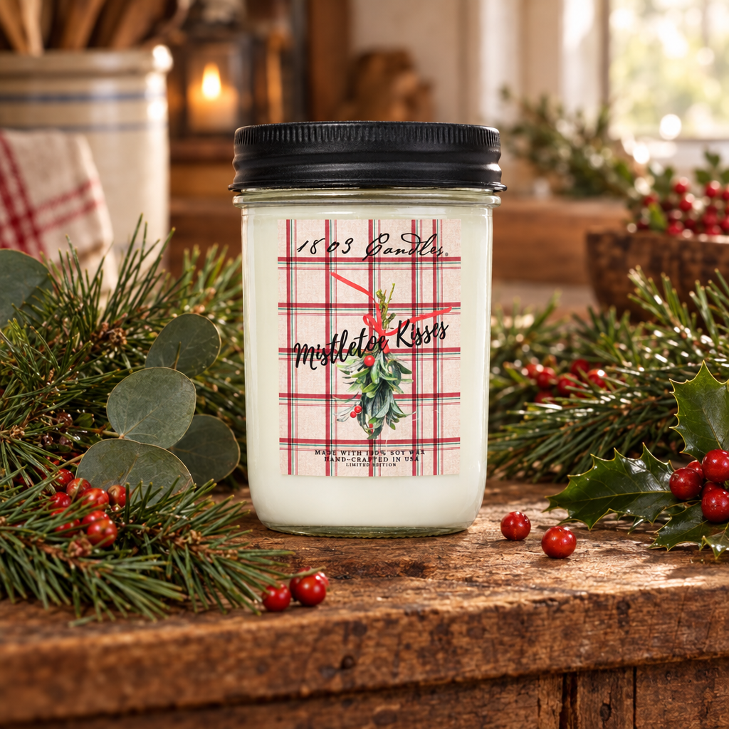 A white candle in a clear glass jar with a black lid sits on a rustic wooden table surrounded by green pine branches, eucalyptus leaves, and red berries. The front label has a red plaid pattern with the text '1609 Earth' and 'Middler Kross' plus a holly illustration.