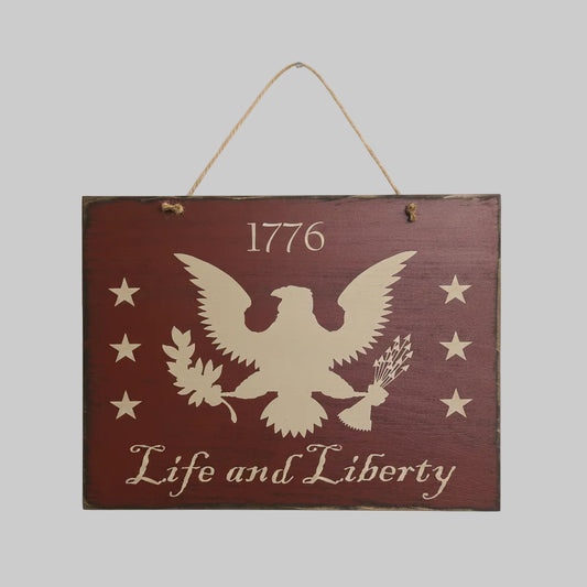 Wooden sign with an eagle design, stars, and '1776 Life and Liberty' text on a gray background.