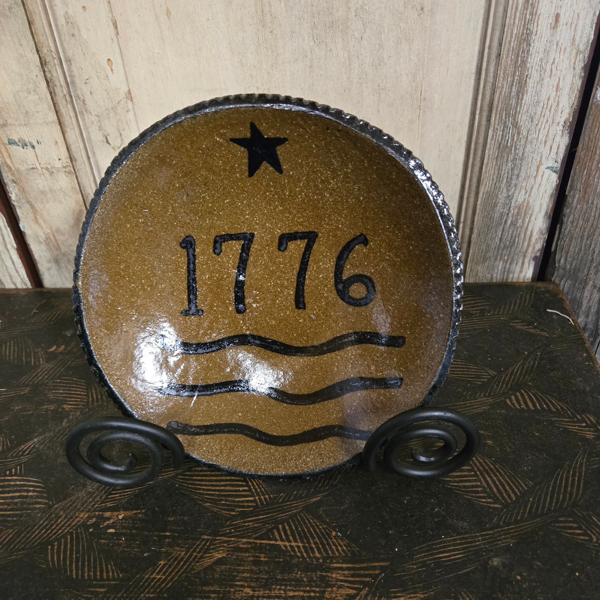 Decorative stoneware plate with patriotic design on a wooden surface