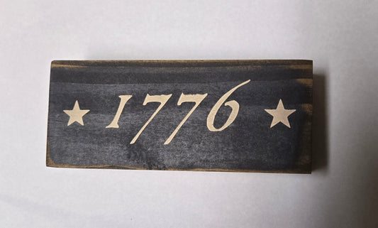 Wooden sign with '1776' and stars on a white background