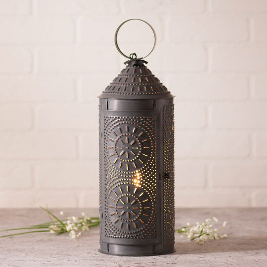 Decorative black lantern with intricate patterns on a light wooden surface.