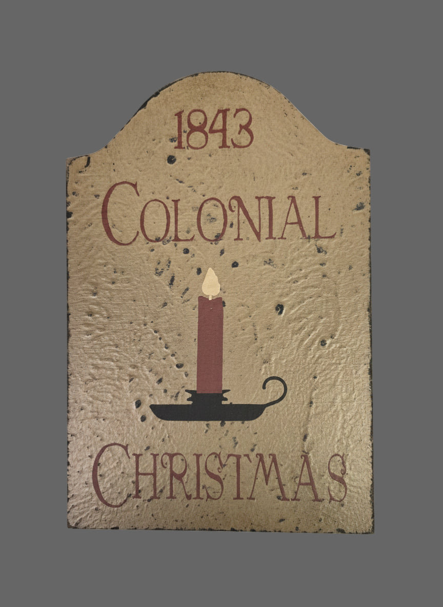 Decorative sign with '1843 Colonial Christmas' text and candle illustration on a textured background.