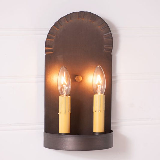 Wall-mounted sconce with two lit candles on a white background