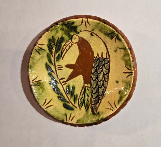 Ceramic tile with a bird design on a beige background