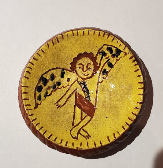 Round yellow object with a stylized drawing of a figure and creature on a white background