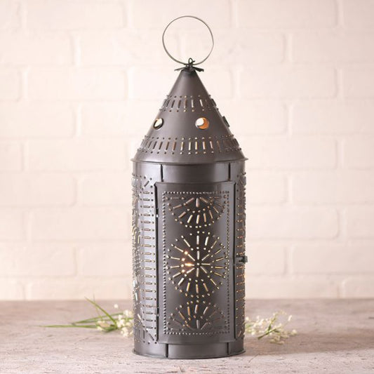 Decorative metal lantern with intricate cut-out patterns on a wooden surface.