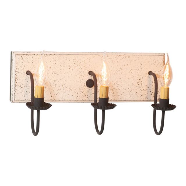 A vintage white three-light vanity light with black textured arms and a textured white painted wooden back, featuring three E12/Candelabra sockets.