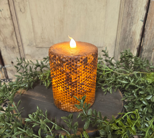 Brown honeycomb pillar candle that runs on batteries and has a timer feature.