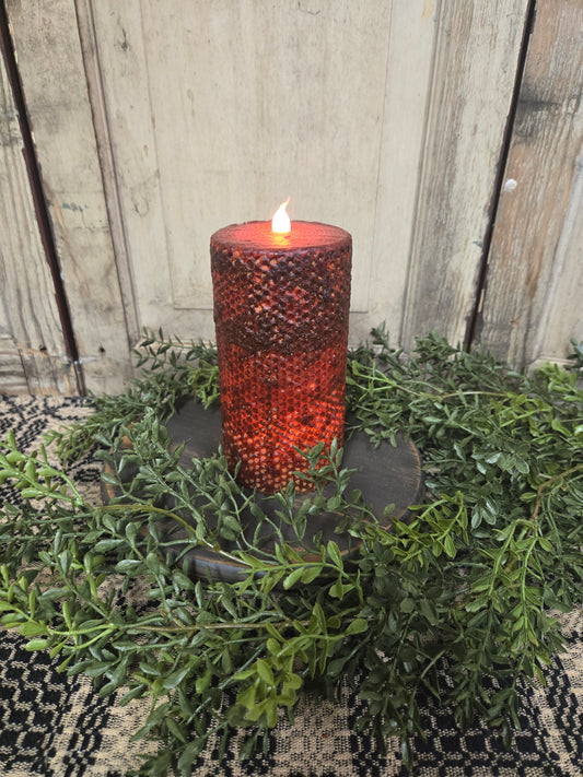 Burgundy honeycomb pillar that runs on batteries and has a timer feature.
