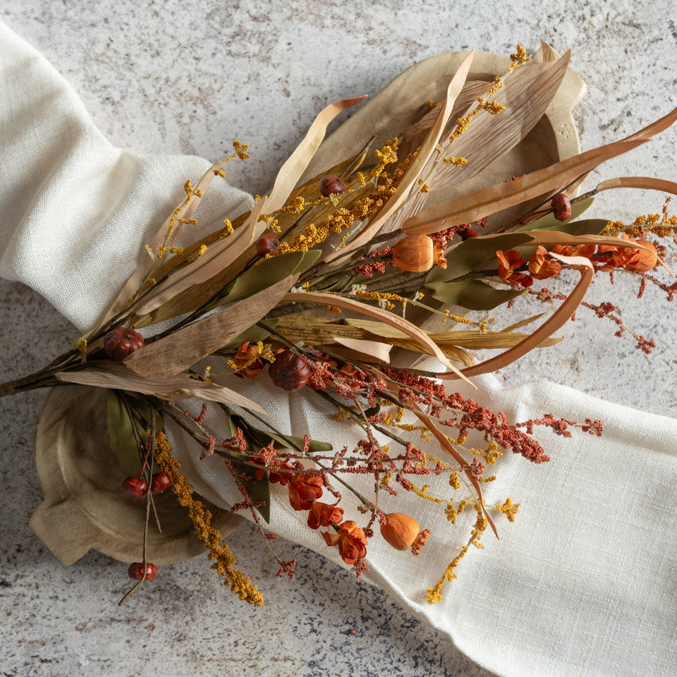 Dried flowers and leaves on a white napkin with a textured background
