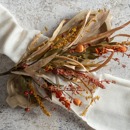 Dried flowers and leaves on a white napkin with a textured background