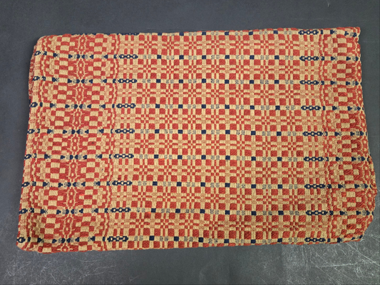 Woven textile with a red and black pattern on a dark background