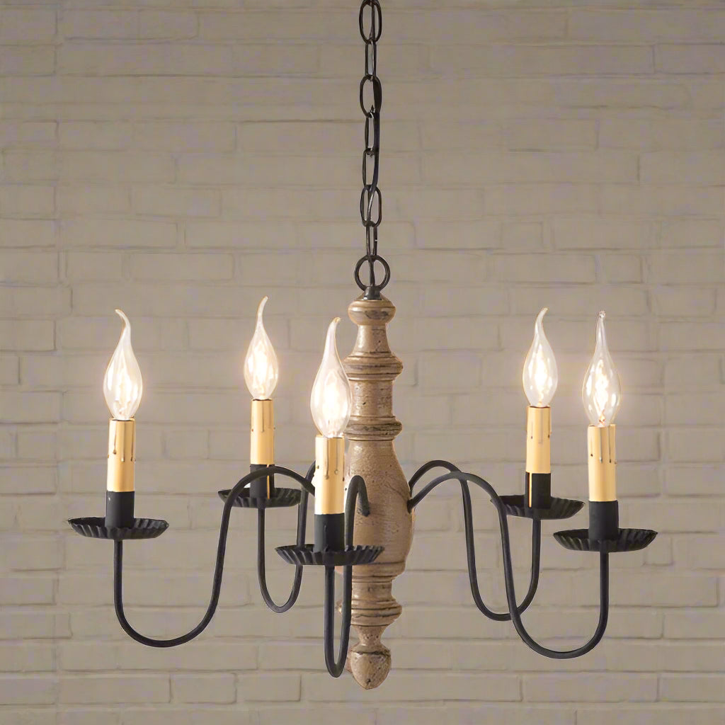 A midsized chandelier with a handspun body in pearwood color, featuring black textured arms and crimped pans, with five E12/Candelabra sockets.