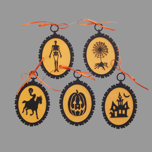 Set of 5 Halloween silhouette ornaments with orange ribbon hangers, featuring designs such as a skeleton, spider, pumpkin, and haunted house.