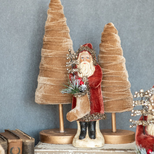 8 inch russet color velvet belsnickel with velvet trees on white bench with old books beside it.