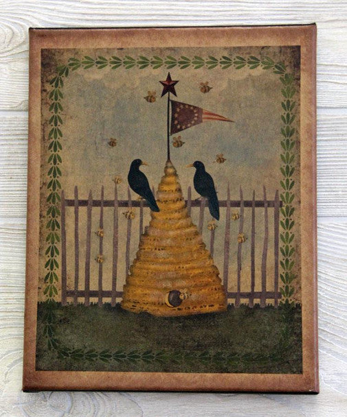 A canvas print featuring a bee skep with a flag, perched on top of a stack of honey, set against a background of a fence and some foliage.