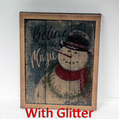 A canvas print featuring a snowman with the phrase 'Believe in Magic' in bold letters, set against a rustic wooden background.