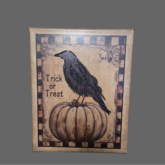 A canvas print featuring a folk art style depiction of a black crow perched on top of a pumpkin, with a 'Trick or Treat' text, and a decorative border.