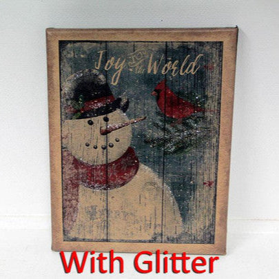 A canvas print featuring a snowman with a 'Joy to the World' message, decorated with birds and set in a rustic wooden frame.