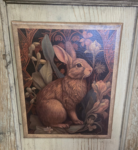 An 8 x 10 inch canvas print featuring a Nouveau style illustration of a bunny with floral elements, displayed on a wooden surface.