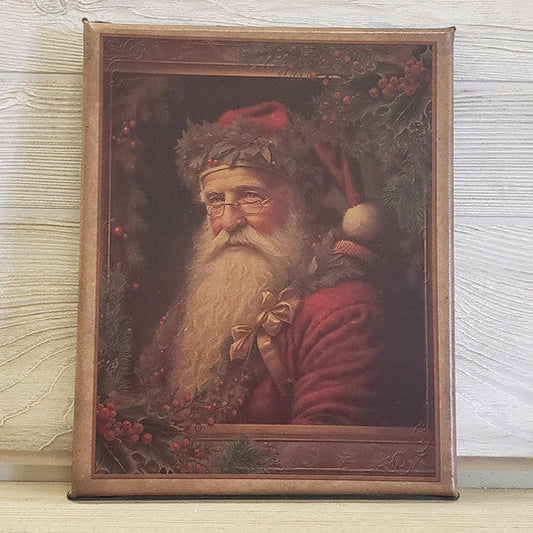 An 8x10 canvas print featuring a portrait of Santa Claus with a Christmas-themed background, framed in a simple brown wood frame.