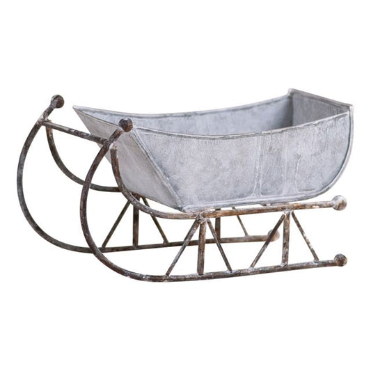 Rustic white-washed metal tin sleigh with solid steel runners and a aged appearance.