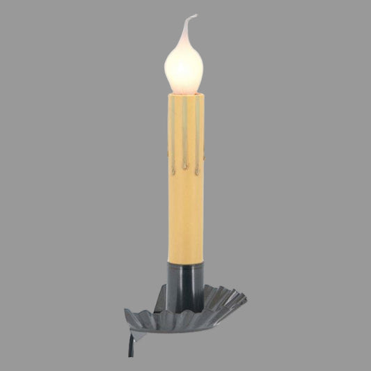 A window sill light that fits between window and sill with a country tin finish, featuring a candle-like appearance with a warm glow.