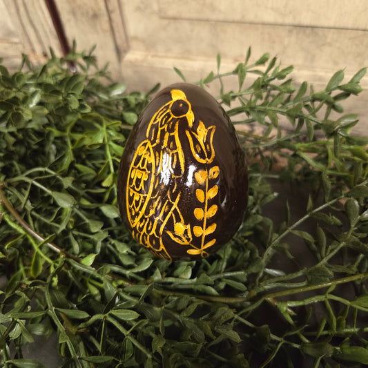 Brown redware egg with yellow glazed feathered bird and flower