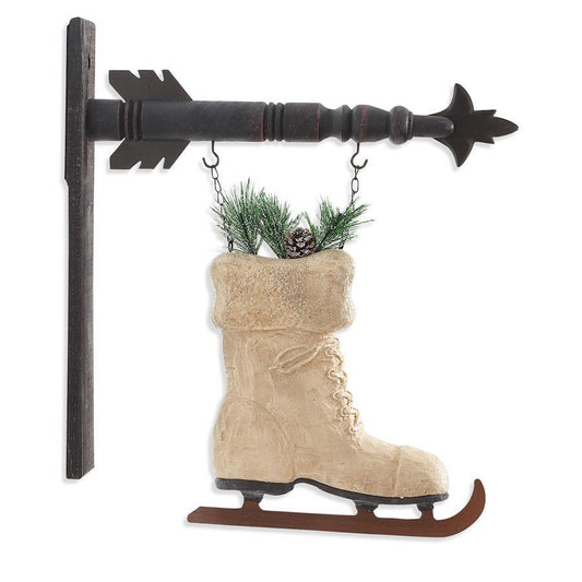 Decorative wall hanging with ice skate boot and arrow design on a white background