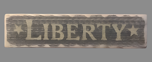 A rectangular wooden sign with the word 'Liberty' carved out in a large, bold font, with star decorations above the text and a beige border at the top.