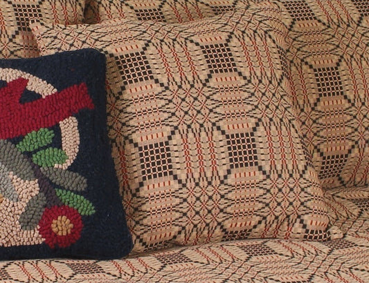 Textile with geometric pattern and a colorful embroidered pillow.