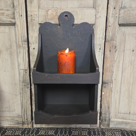 Two shelf cabinet in a rustic black color with a battery operated candle