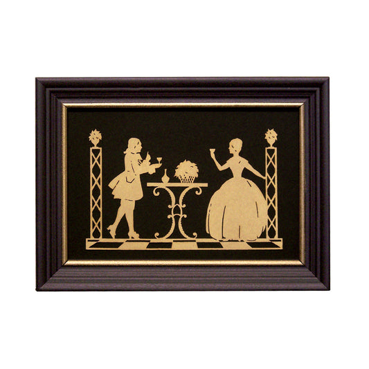 Framed paper cutting artwork featuring two silhouetted figures, one standing and the other seated, with a decorative border and a glass cover.