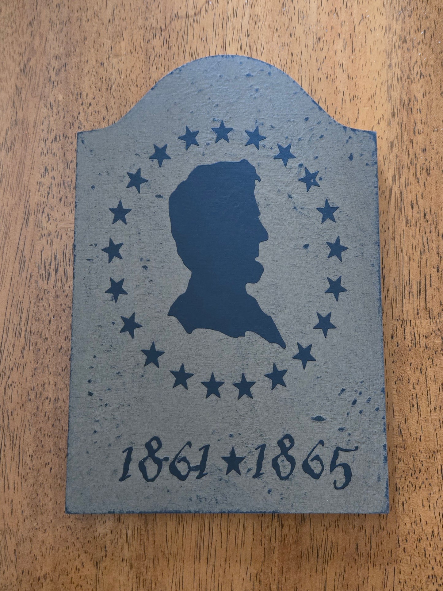 Memorial stone with silhouette and dates on a wooden surface