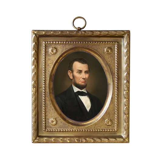 An antique-style gold-toned metal portrait frame featuring an oval portrait of Abraham Lincoln, with a hanging loop at the top, shown against a plain white background.