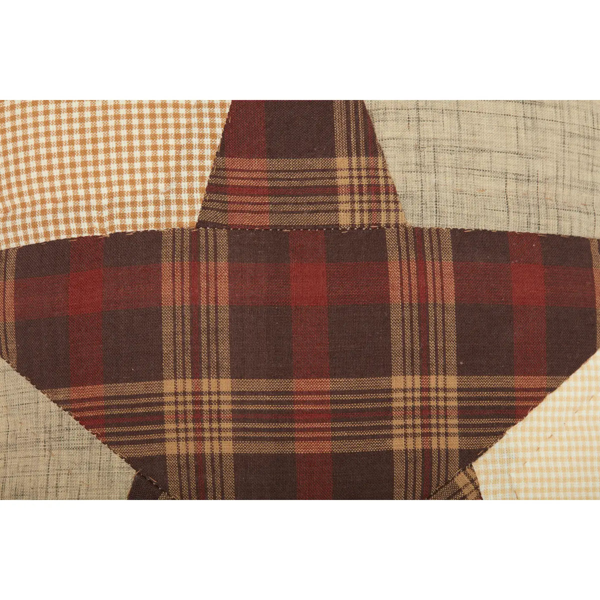 Close-up of the Abilene Star pillow’s burgundy plaid star and cream and tan patchwork fabrics.