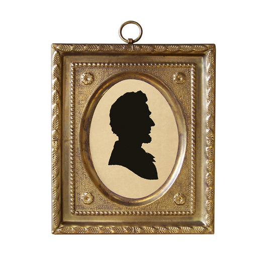 A brass frame miniature silhouette of Abraham Lincoln with a fabric backing.
