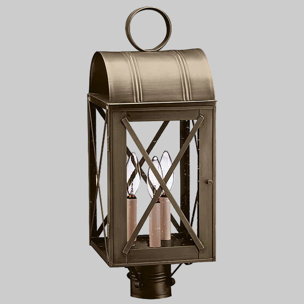 Bronze outdoor lantern with crossbar design on a gray background