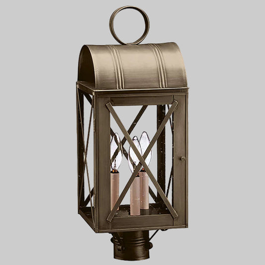 Bronze outdoor lantern with crossbar design on a gray background