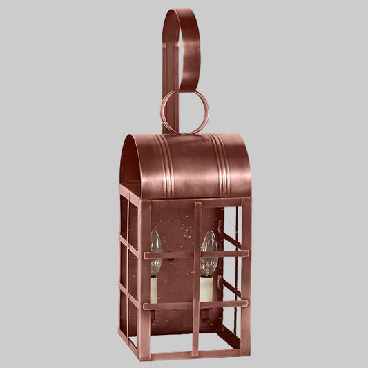 Copper lantern with two candle holders on a gray background