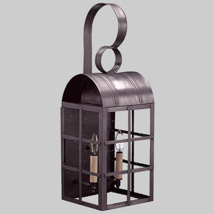Decorative metal lantern with a circular design on top against a gray background