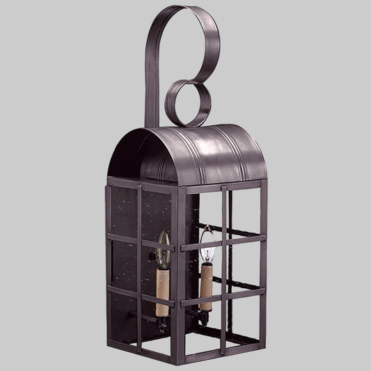 Decorative metal lantern with a circular design on top against a gray background