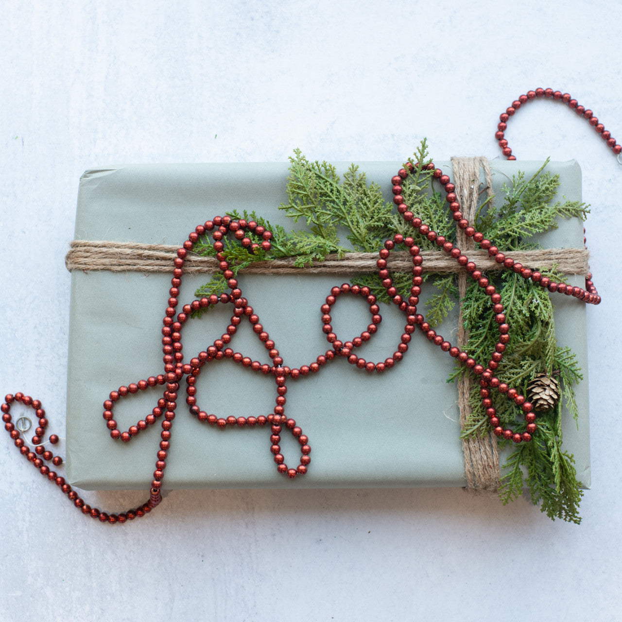 Red bead garland displayed with greenery