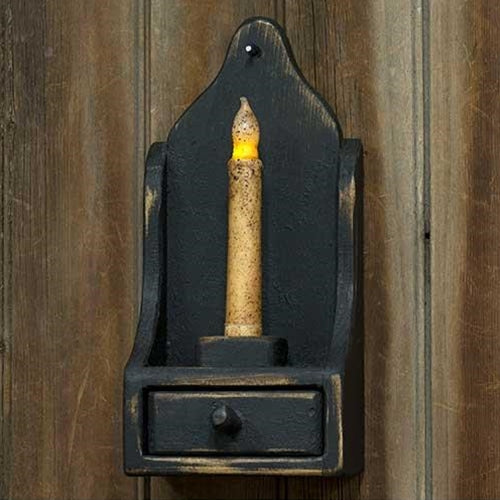 A rustic wooden wall sconce with a black painted finish, featuring a drawer at the base and a taper candle.