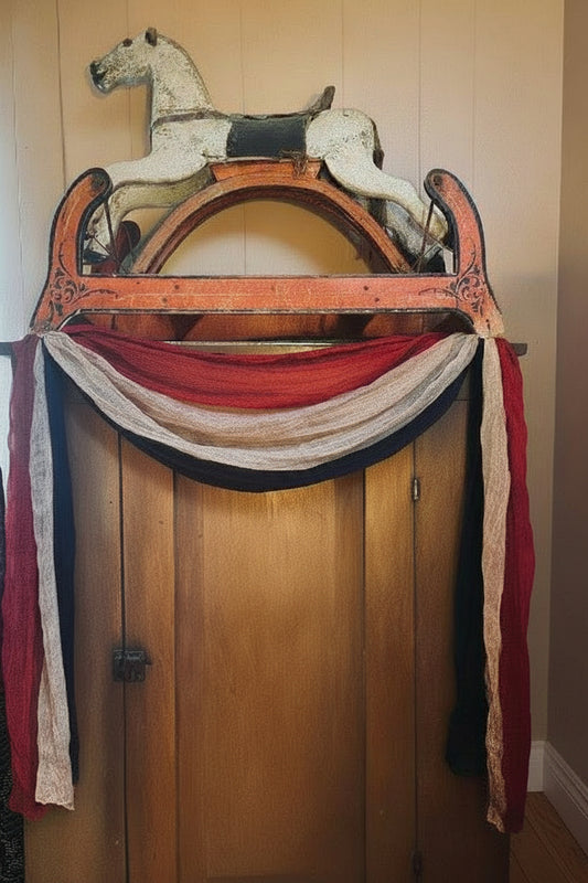 Vintage wooden rocking horse with a decorative arch against a beige wall.