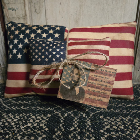 Two American flag pillows with Abe Lincoln tag with jute string.