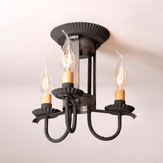 Vintage-style ceiling light fixture with three candle-shaped bulbs on a plain background