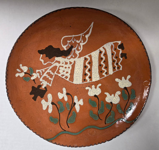 A 10 inch round ceramic plate with a angel and plant design, primarily brown with green and white accents.